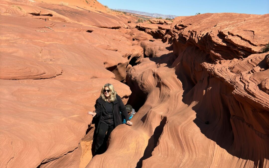 Diane Hatz climbing out of Antelope Canyon red rocks