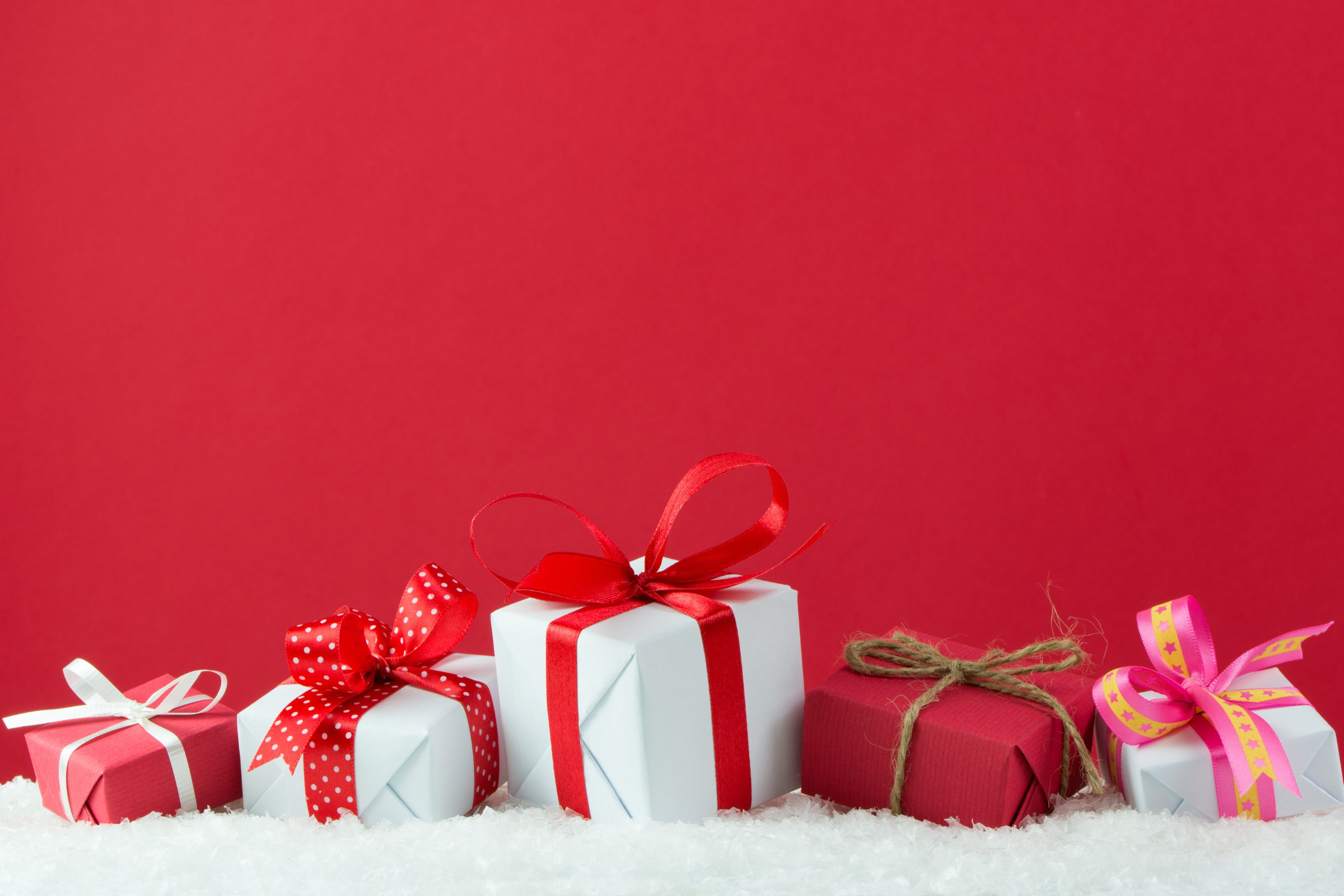 small wrapped presents for Christmas against a red background